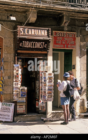 Tourists outside tobacconist selling postcards Valletta Malta Europe Stock Photo