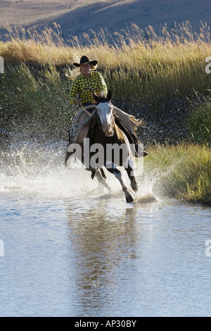 Cowgirl riding in water, wildwest, Oregon, USA Stock Photo