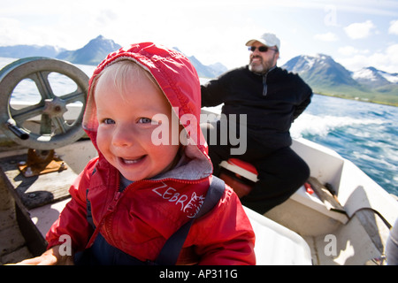 A little girl, child, and man on a fishing boat, Austvagoya Island, Lofoten, Norway Stock Photo