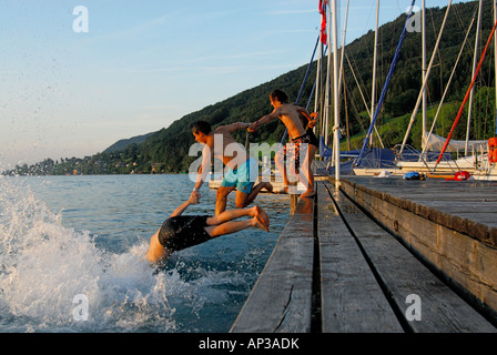 young men diving from landing stage, lake Attersee, Salzkammergut, Salzburg, Austria Stock Photo