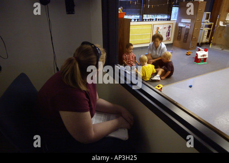 Hearing impaired children at play are observed through a one way mirror at an Orange, CA speech & hearing clinic. Stock Photo