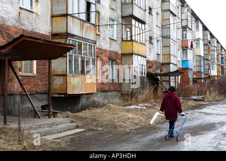 Concrete buildings and person on the street, Yelizovo, close to Petropavlovsk, Kamchatka, Sibiria, Russia Stock Photo