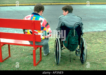 Couple age 30 resting in wheelchair at the MN State Fair. St Paul Minnesota MN USA Stock Photo