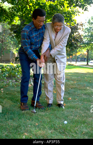 Black couple age 70 practicing golf swing. St Paul Minnesota MN USA Stock Photo