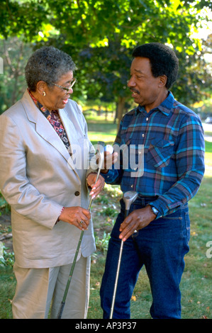 black couple age 70 discussing golf swing. St Paul Minnesota MN USA Stock Photo