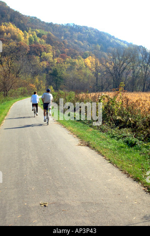 Spouses age 55 bicycling on the Root River State Trail. Lanesboro Minnesota MN USA Stock Photo