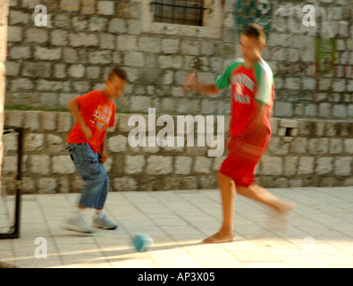 Two children playing football in the back streets of Dubrovnik Stock Photo