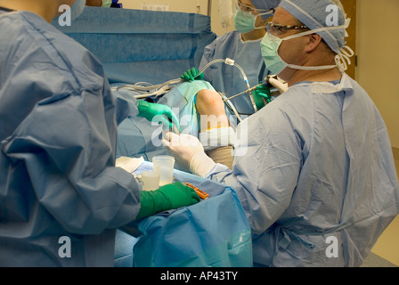 Surgical team performing arthroscopic knee surgery in hospital operating room Stock Photo