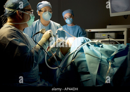 Surgical team performing arthroscopic knee surgery in hospital operating room Stock Photo