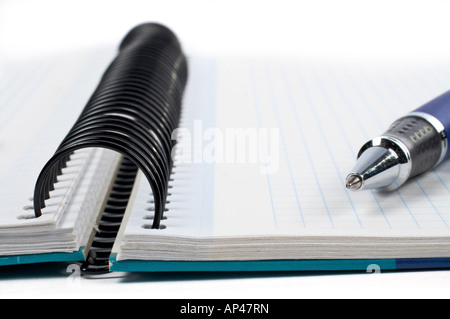 Detail of pen and notebook with shadow over a white background Small DOF Stock Photo