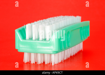 Green Nailbrush on a red background Stock Photo