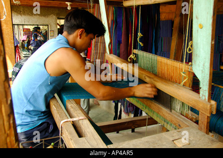 Central America, Guatemala, Western Highlands, Lake Atitlan, San Antonio Palopo. Young man weaving on a traditional loom. Stock Photo
