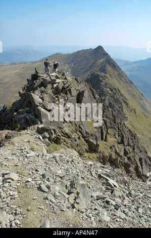 Two male walkers on the ridge walk along Striding Edge towards the summit of Helvellyn in the English Lake District Stock Photo