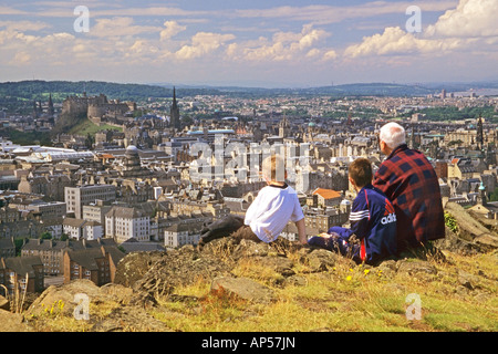 Family on the top of Salisbury Crags in Holyrood Park looking at Edinburgh Castle Stock Photo