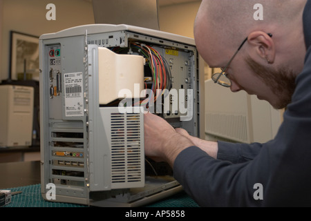 Forensics expert taking harddrive out of suspect s computer for further study Nebraska State Patrol Crime Lab Stock Photo