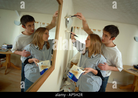 A young happy couple painting the walls of their first home Stock Photo
