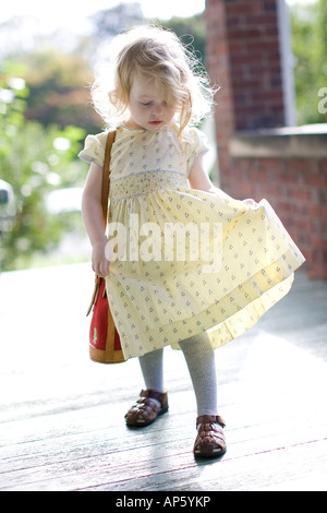 ©David Howells 2007 Tel +1 305 778 1846 Blonde two year old girl looks down at her dress. Stock Photo