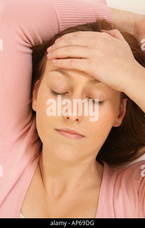 young woman holding her head as if she has a headache. Stock Photo