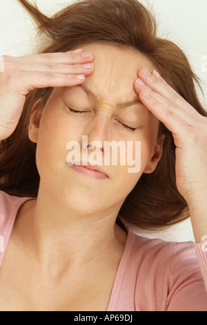 young woman holding her head as if she has a headache. Stock Photo