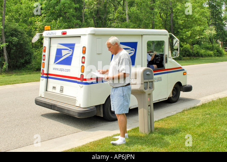 A United States postal carrier delivers mail to residences in Stock ...