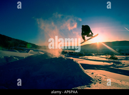 Snowboarder in mid-air jump at sunset in Colorado, USA Stock Photo