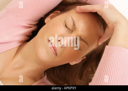 young woman holding her head as if she has a headache. Stock Photo