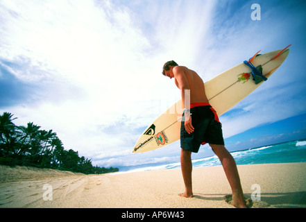 Surfer walking in sand on North Shore, Oahu, Hawaii Stock Photo