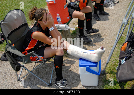 Female softball player sprains ankle from Sports injury due to playing baseball Stock Photo