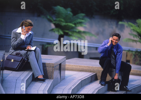 Business people with cellphones and briefcases on steps in downtown Los Angeles Stock Photo