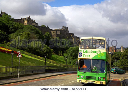 A green tourist bus on the Mound with the Castle behind, Edinburgh SCOTLAND Stock Photo