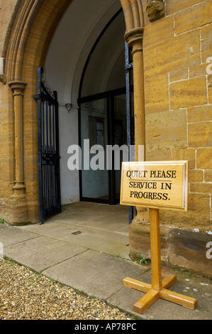 Wooden sign with the wording Quiet Please Service in Progress, placed outside a church entrance Stock Photo