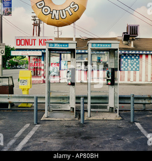 Old phone booths in parking lot in front of a donut store Stock Photo