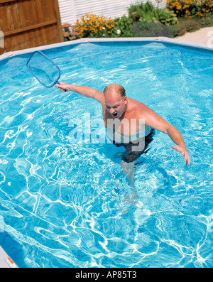 Man with net in backyard pool trying to catch non existent fish Chicago  Illinois USA Stock Photo - Alamy