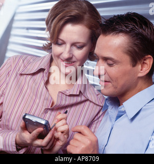 Close-up of two businesspeople using personal organizer Stock Photo
