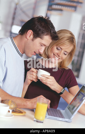 Young couple looking at laptop and smiling Stock Photo