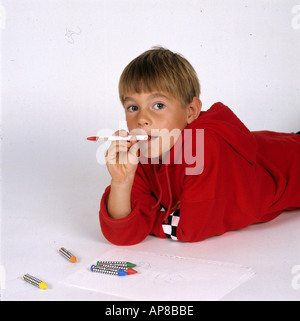 Portrait of a boy holding a pen in his mouth Stock Photo