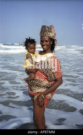 Good looking young African woman and baby paddling in sea on Labadi beach Accra Ashanti region Ghana West Africa Stock Photo
