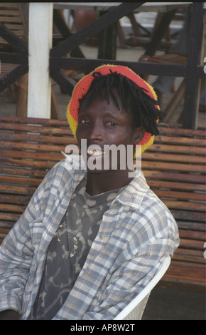 Smiling young black African man relaxing on a bench near Labadi beach Accra Ashanti region Ghana West Africa Stock Photo