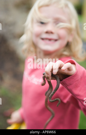 six year old girl holding leaf in front of her face Stock Photo - Alamy