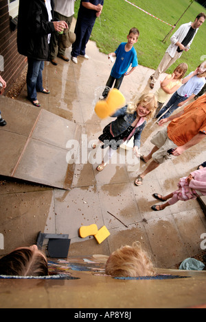 Children throwing wet sponges at people at a school fete Stock Photo