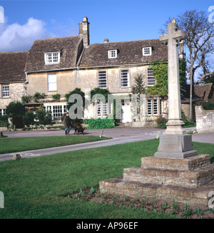 Village green war memorial and houses Biddestone Wiltshire England Stock Photo