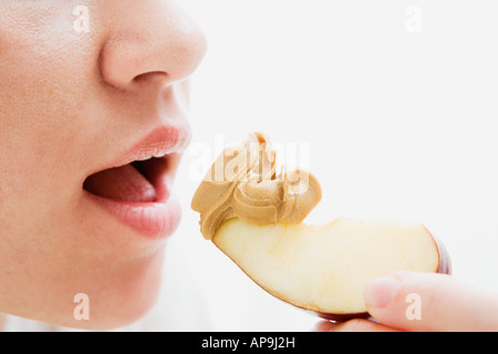 Woman eating apple and peanut butter Stock Photo