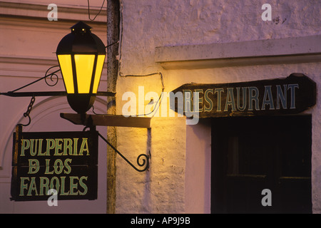 Old lamp on wall illuminating name of restaurant in Colonia del Sacramento Uruguay Stock Photo