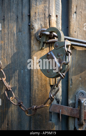 Unlocked old  pad lock hanging on door hasp Stock Photo