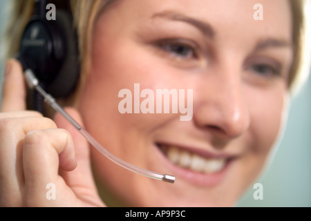 Woman using telephone headset, smiling Stock Photo