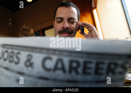 A man looking for a job in the Classified section of the newspaper. Stock Photo