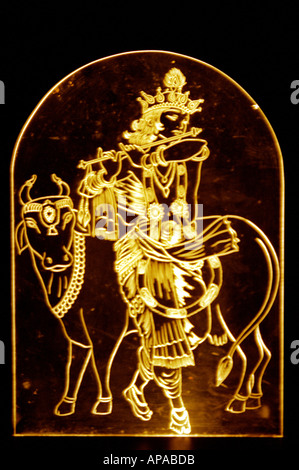 Indian Hindu God Lord Krishna glass sculpture playing flute with cow India Stock Photo
