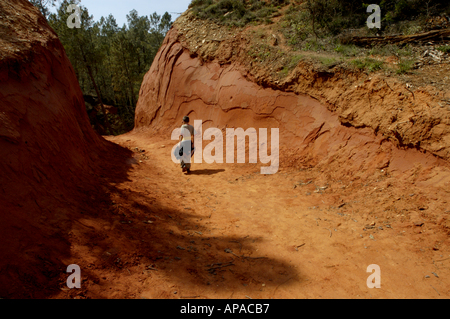 France Provence The Rustrel Canyon Young Boy Walking On A Red Sandy Dirt Stock Photo