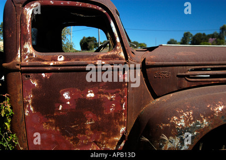 Door detail of rusty old Ford truck left to decay in Ravenswood a Gold Rush town near Townsville Queensland Australia Stock Photo