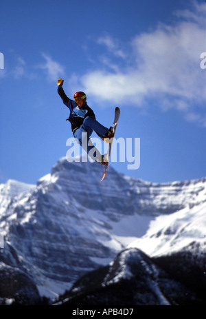 Snowboarder performing grab at big air competition in Canada Stock Photo